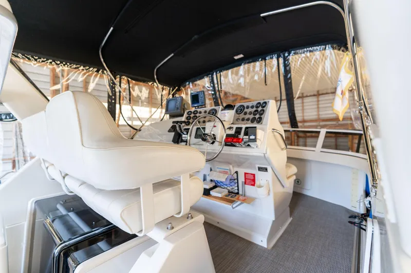 Slide: The Image of 1998 Carver 355 Aft Cabin helm with white seating and navigation instruments. - 32