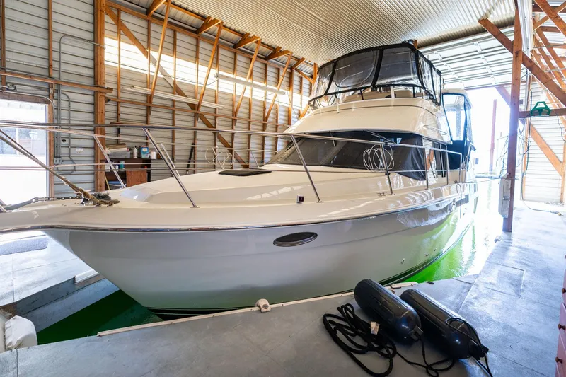 Slide: The Image of 1998 Carver 355 Aft Cabin yacht docked in a boathouse. - 42