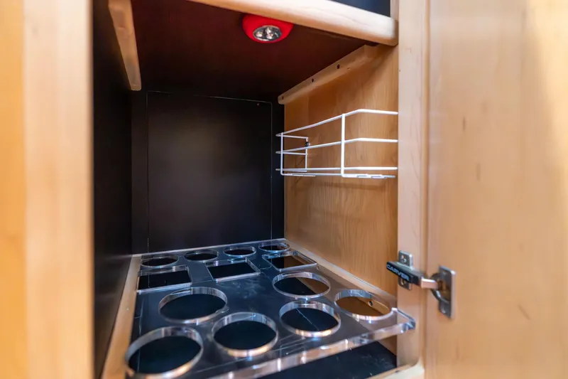 Slide: The Image of 1998 Carver 355 Aft Cabin interior cabinet with cup holders and wire rack. - 49