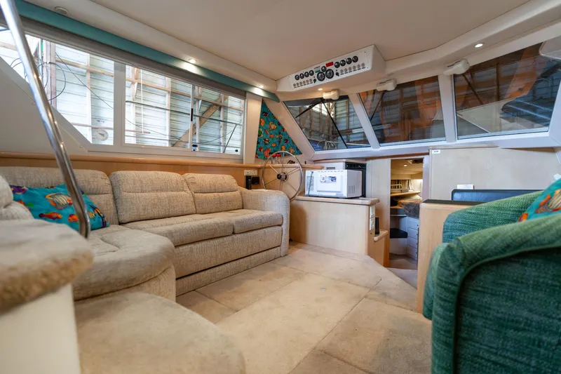 Slide: The Image of 1998 Carver 355 Aft Cabin interior with beige seating and nautical decor. - 6