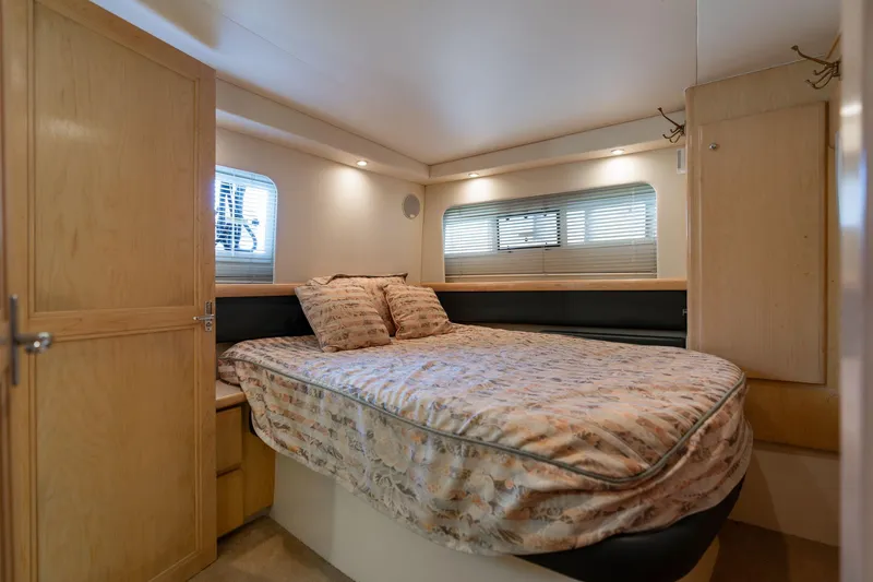 Slide: The Image of 1998 Carver 355 Aft Cabin bedroom with cozy bed and wooden cabinetry. - 9