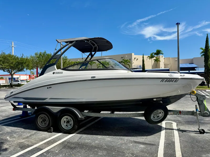 Slide: The Image of 2017 Yamaha Boats 212 Limited S on trailer in parking lot, sunny day. - 4
