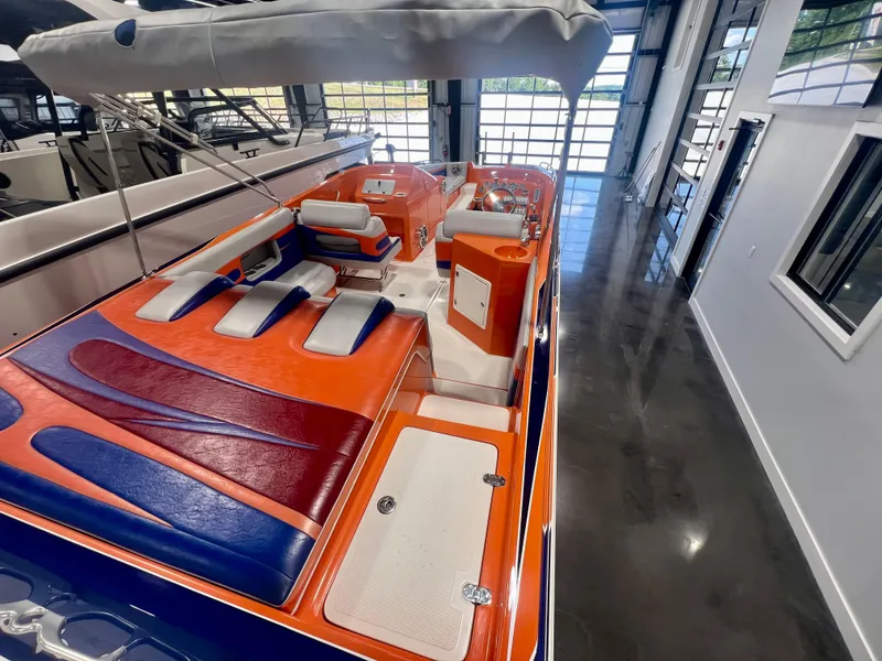 Slide: The Image of 2008 Shockwave Fundeck boat with vibrant orange and blue interior, displayed indoors. - 10