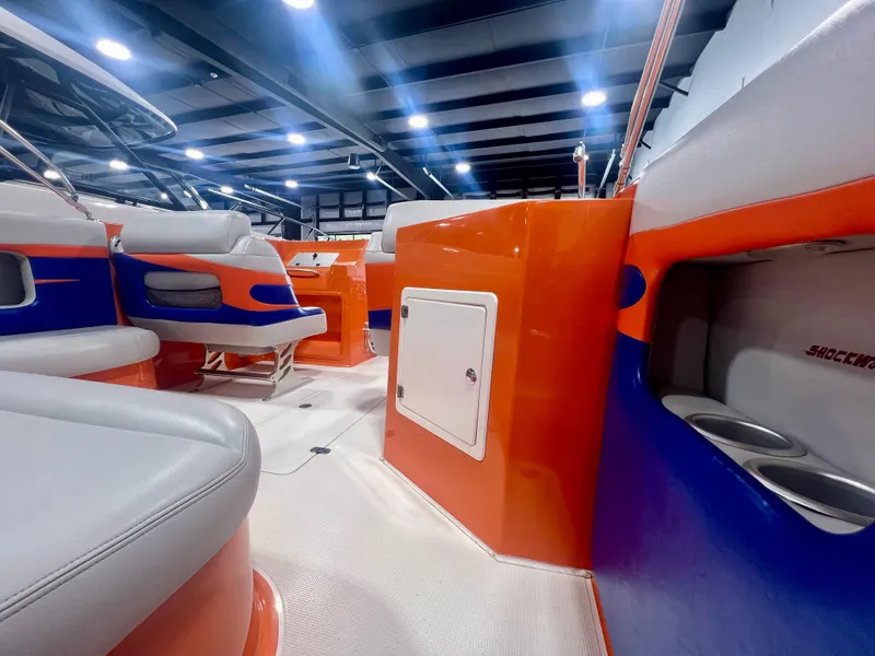 Slide: The Image of Interior of a 2008 Shockwave Fundeck boat with vibrant orange and blue seating. - 12