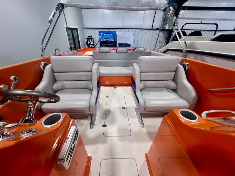 Slide: The Image of 2008 Shockwave Fundeck boat interior with orange and gray seating, steering wheel, and cup holders. - 13