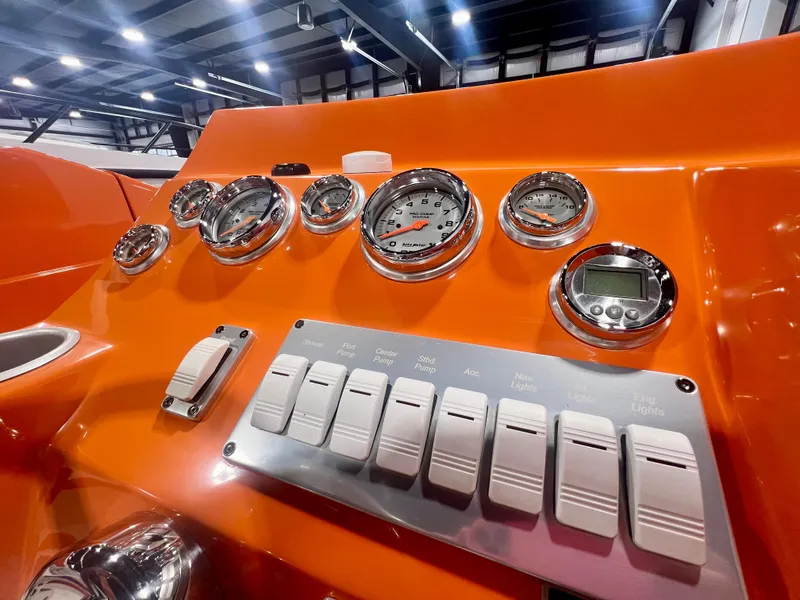 Slide: The Image of Orange dashboard of 2008 Shockwave Fundeck boat with gauges and switches. - 16