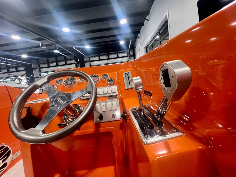 Slide: The Image of Orange dashboard of a 2008 Shockwave Fundeck boat with steering wheel and controls. - 17