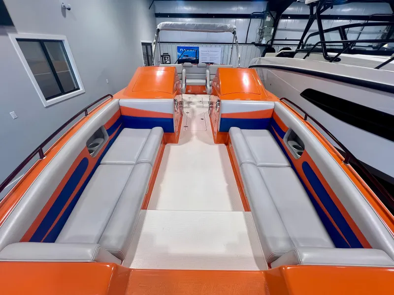 Slide: The Image of 2008 Shockwave Fundeck boat with orange and blue seating in a showroom. - 21