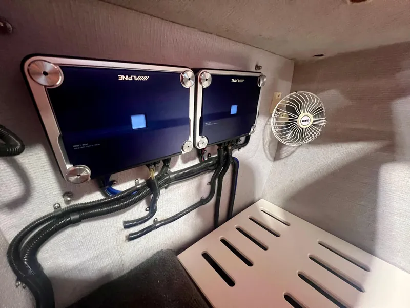 Slide: The Image of 2008 Shockwave Fundeck interior with dual Alpine amplifiers and a cooling fan. - 25