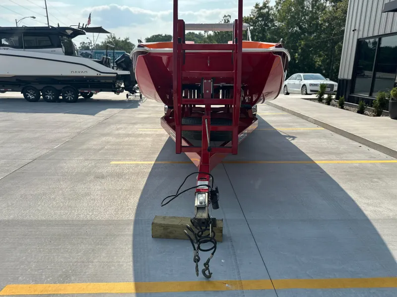 Slide: The Image of 2008 Shockwave Fundeck boat on red trailer in parking lot. - 5