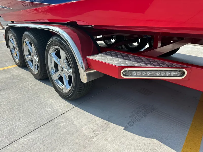 Slide: The Image of Red 2008 Shockwave Fundeck trailer with chrome wheels and LED lights on concrete surface. - 7