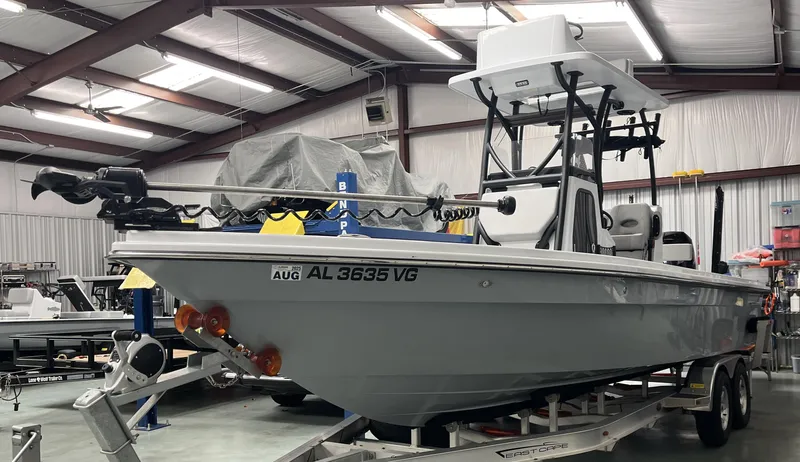 Slide: The Image of 2025 East Cape 25 Open boat in a garage, on a trailer, with visible registration. - 2