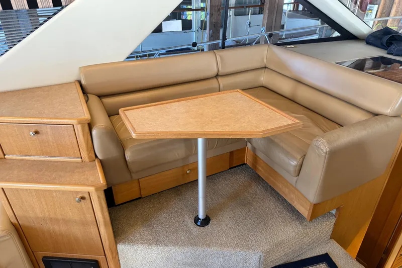 Slide: The Image of 2000 Bayliner 3988 Command Bridge Motoryacht interior with beige leather seating and wooden table. - 10