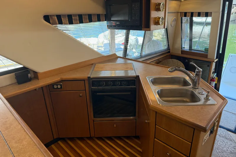 Slide: The Image of Interior of 2000 Bayliner 3988 Command Bridge Motoryacht kitchen with sink, stove, and microwave. - 11