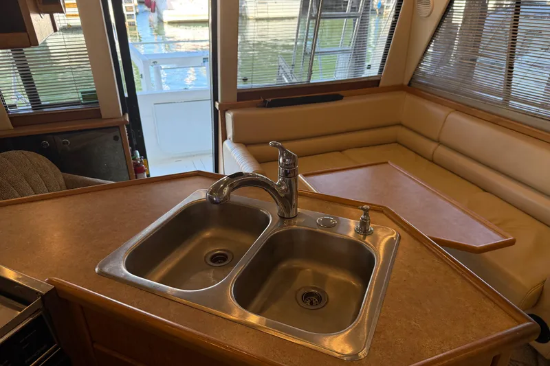 Slide: The Image of Interior of 2000 Bayliner 3988 yacht showing kitchen sink and seating area. - 16