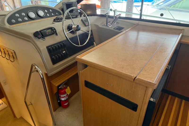 Slide: The Image of 2000 Bayliner 3988 Command Bridge Motoryacht helm with steering wheel and control panel. - 18