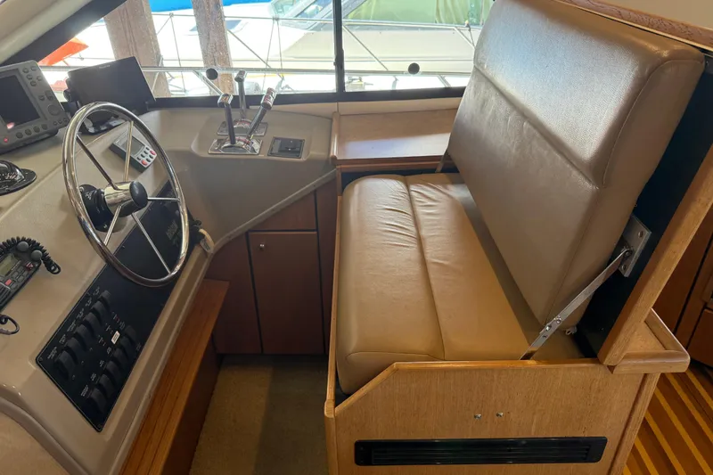 Slide: The Image of 2000 Bayliner 3988 Command Bridge Motoryacht helm with steering wheel and controls. - 19