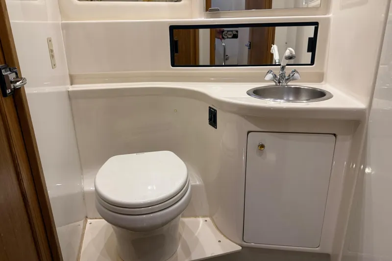 Slide: The Image of 2000 Bayliner 3988 Command Bridge Motoryacht bathroom with toilet, sink, and storage cabinet. - 48