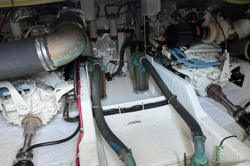 Slide: The Image of Engine room of 2000 Bayliner 3988 Command Bridge Motoryacht, showcasing mechanical components and piping. - 65