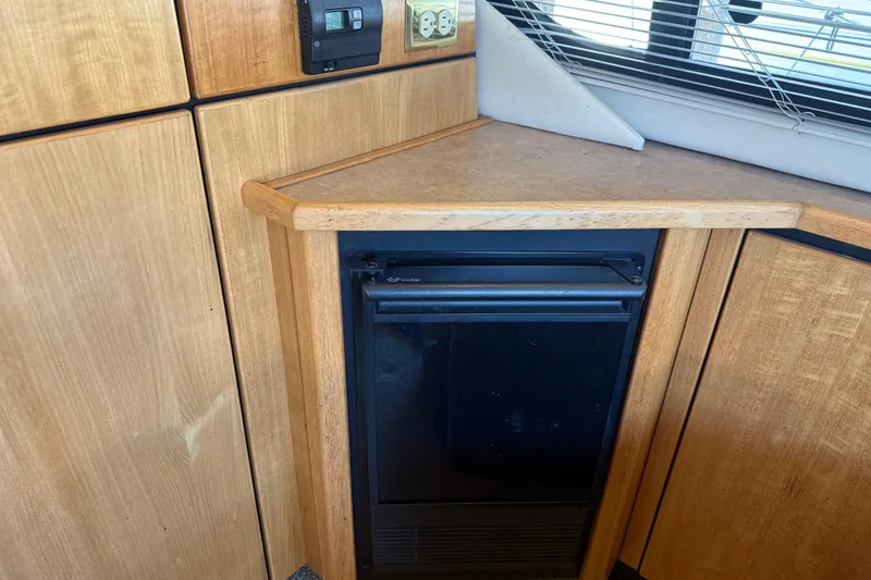Slide: The Image of Wooden interior of 2000 Bayliner 3988 Command Bridge Motoryacht with compact fridge and countertop. - 7