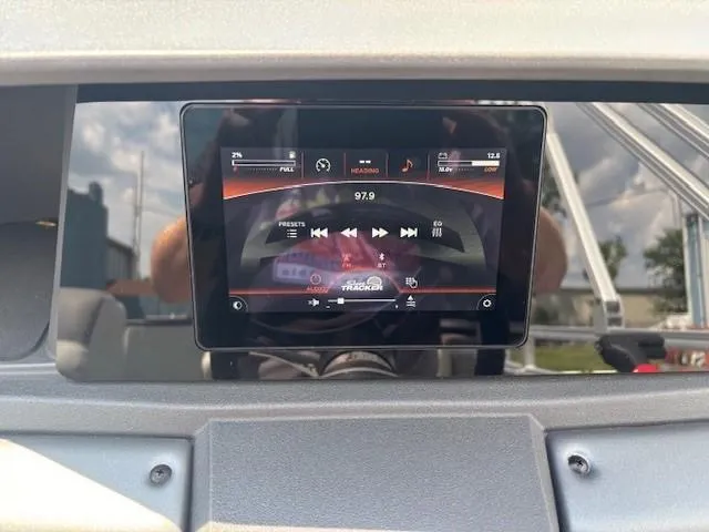 Slide: The Image of 2026 Sun Tracker Fishin' Barge 20 DLX dashboard with digital display showing audio controls. - 20