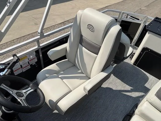 Slide: The Image of 2026 Sun Tracker Fishin' Barge 20 DLX captain's chair with steering wheel, gray upholstery. - 22
