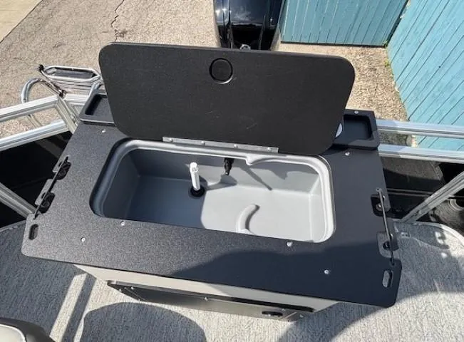 Slide: The Image of 2026 Sun Tracker Fishin' Barge 20 DLX livewell, open lid, gray interior, black trim. - 26