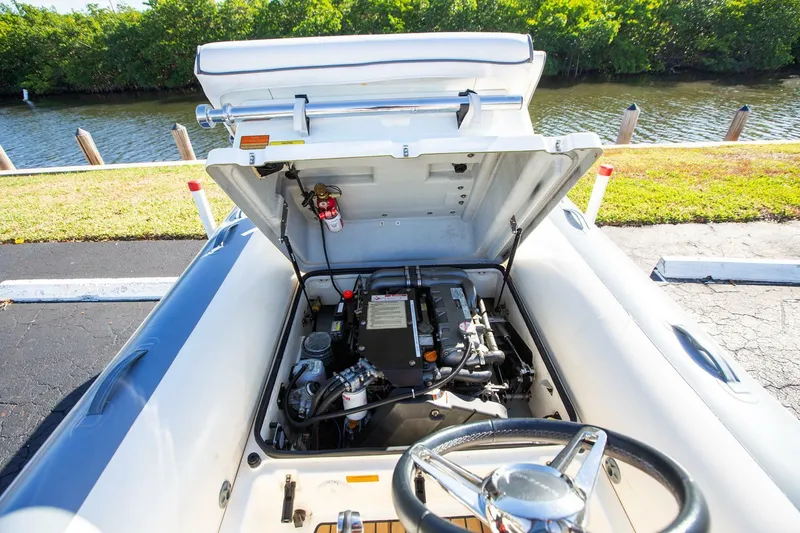 Slide: The Image of 2018 Williams Jet Tenders 505 Dieseljet engine compartment, open hood, parked by water. - 12