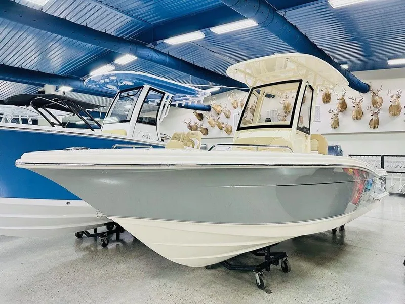 Slide: The Image of 2026 Scout 215 XSF boat displayed indoors with mounted deer heads on the wall. - 1