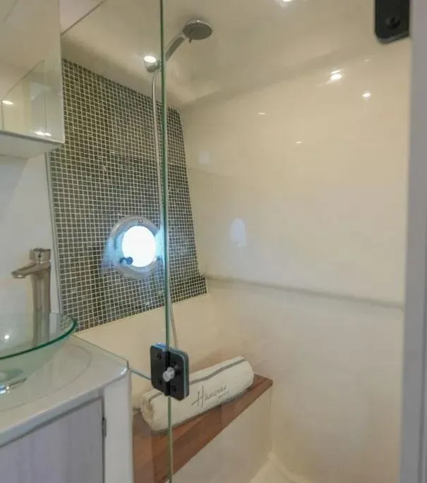 Slide: The Image of Modern shower in Hanover 387 yacht, featuring glass door and porthole window, 2025 model. - 25