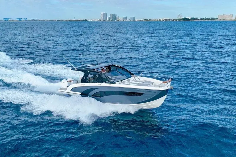 Slide: The Image of 2025 Hanover 387 boat cruising on open blue sea near city skyline. - 3