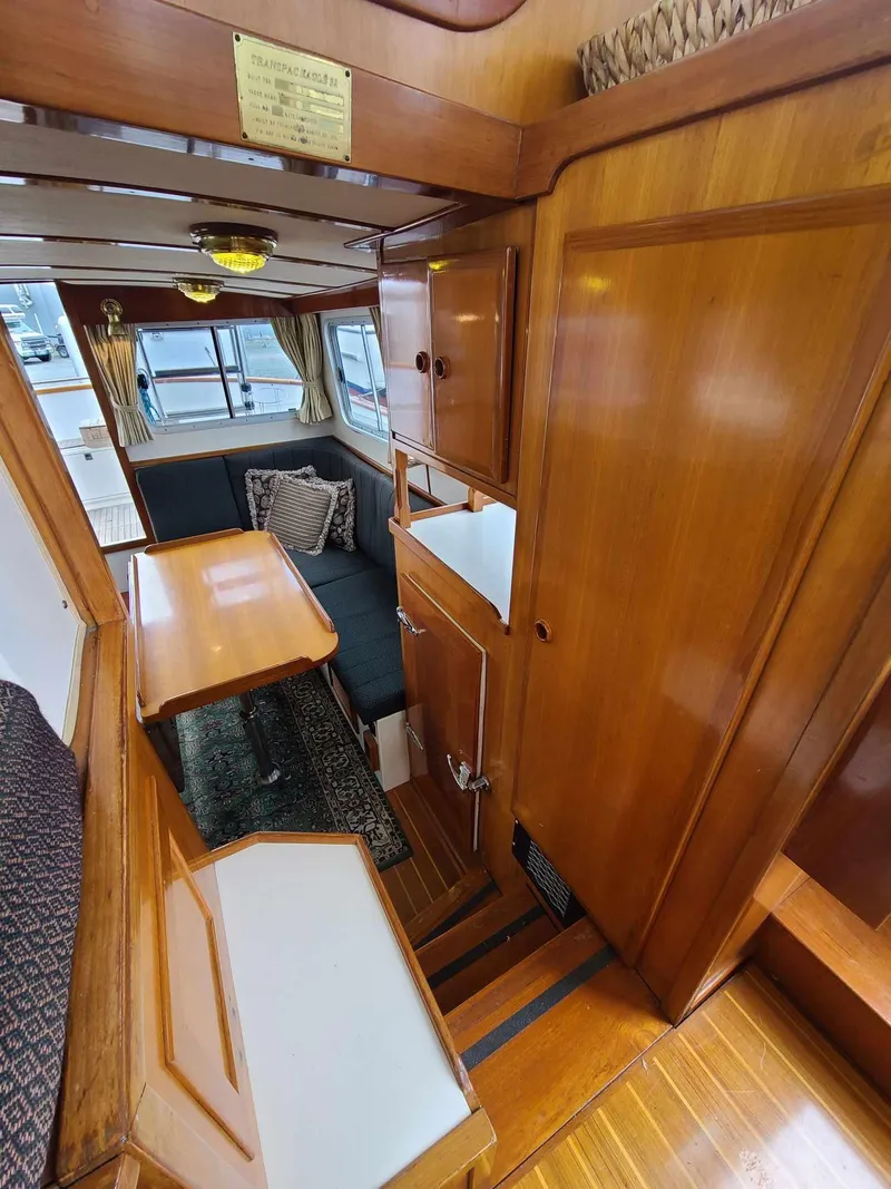 Slide: The Image of 1989 Eagle 32 Trawler interior with wooden finish, dining area, and cozy seating. - 15
