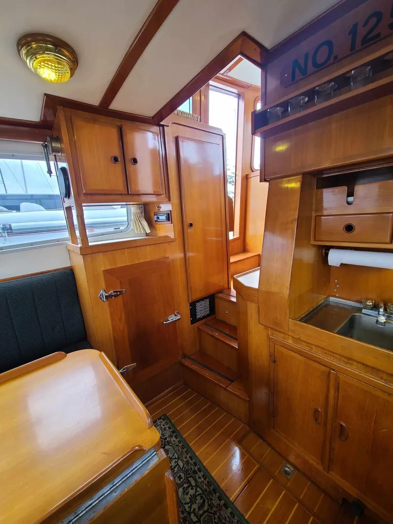 Slide: The Image of Interior of a 1989 Eagle 32 Trawler with wooden cabinetry and compact kitchen area. - 17