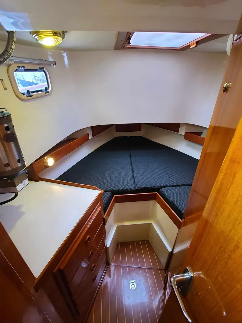 Slide: The Image of 1989 Eagle 32 Trawler cabin interior with wood finish and cozy sleeping area. - 21
