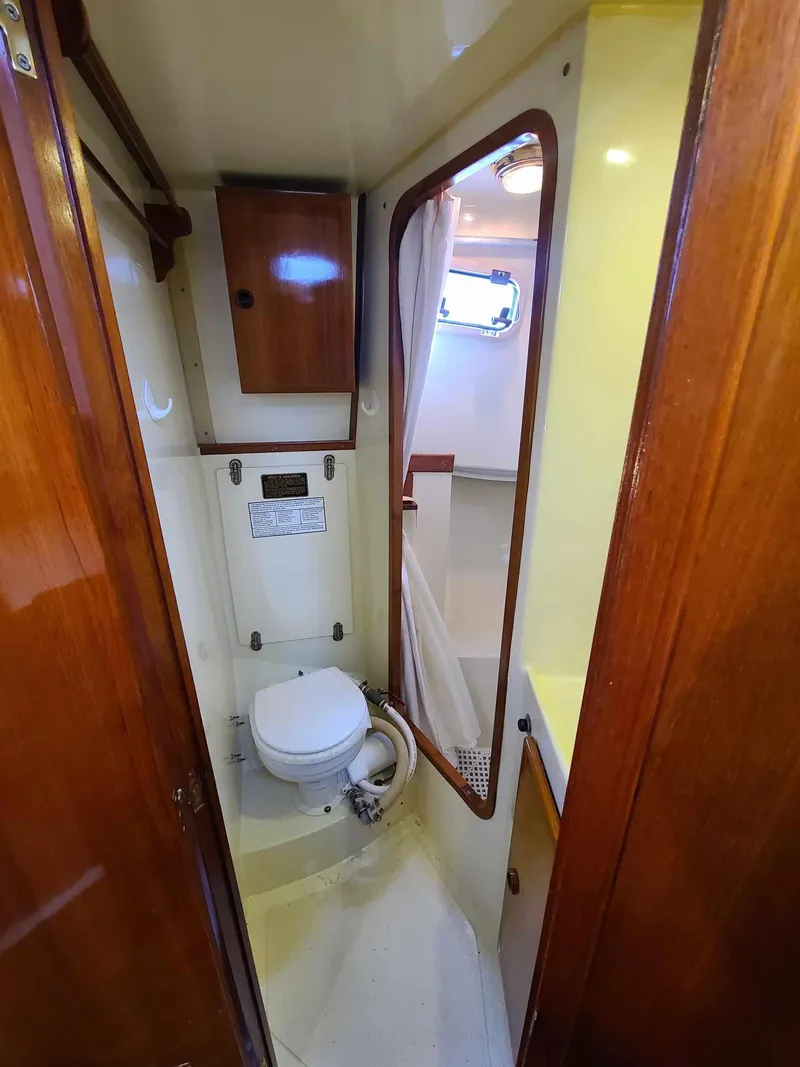 Slide: The Image of 1989 Eagle 32 Trawler bathroom with wooden cabinetry and compact toilet. - 23