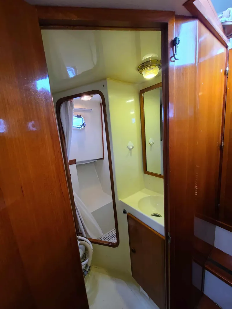 Slide: The Image of 1989 Eagle 32 Trawler bathroom with wooden cabinetry and compact shower area. - 25