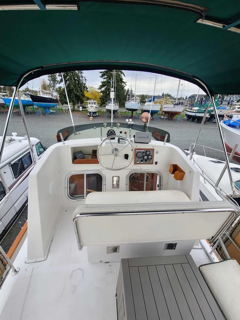 Slide: The Image of 1989 Eagle 32 Trawler helm with canopy, docked among other boats. - 4
