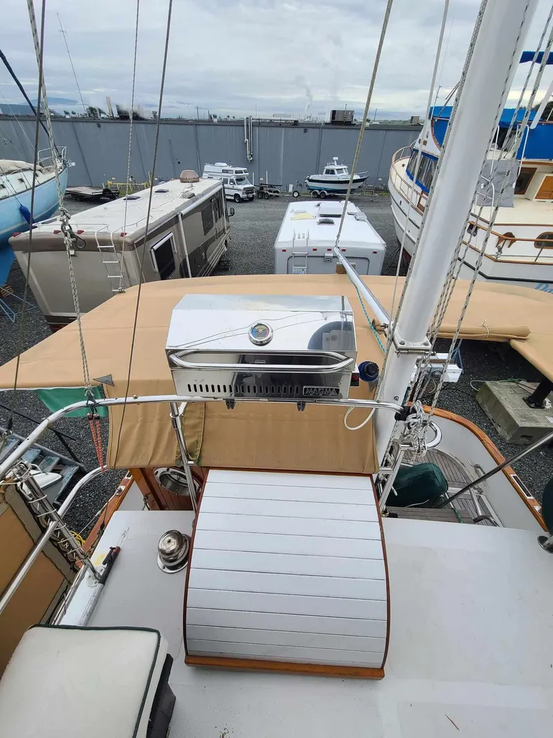 Slide: The Image of 1989 Eagle 32 Trawler on deck, featuring a grill and covered seating area. - 5