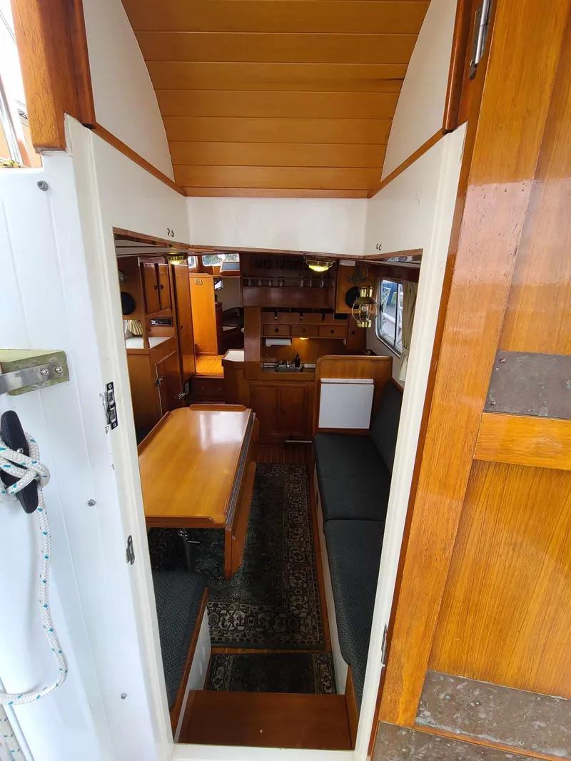 Slide: The Image of Interior view of 1989 Eagle 32 Trawler, featuring wood paneling and seating area. - 6