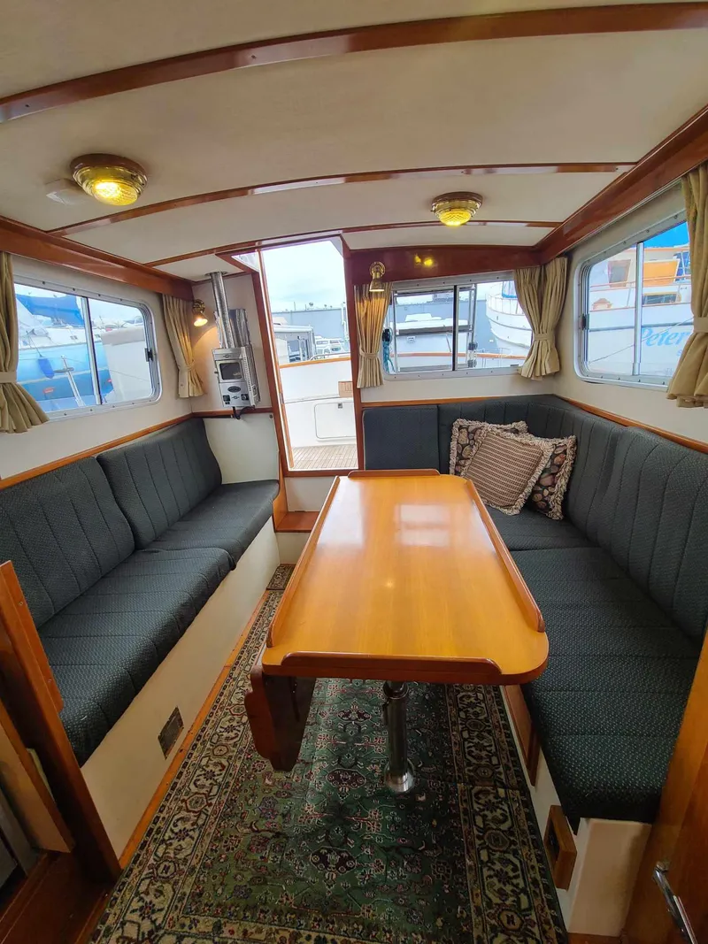 Slide: The Image of Interior of 1989 Eagle 32 Trawler with cozy seating and wooden table. - 7