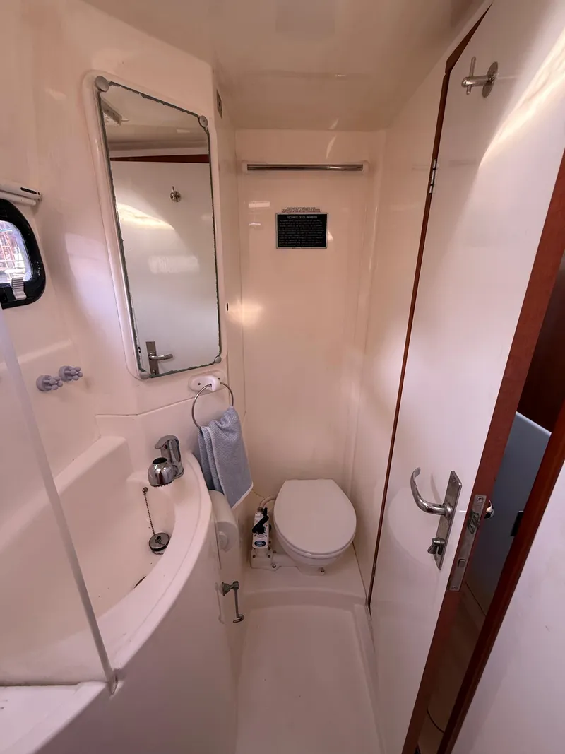 Slide: The Image of Compact bathroom in a 2010 Leopard 38 yacht with sink, toilet, and mirror. - 12