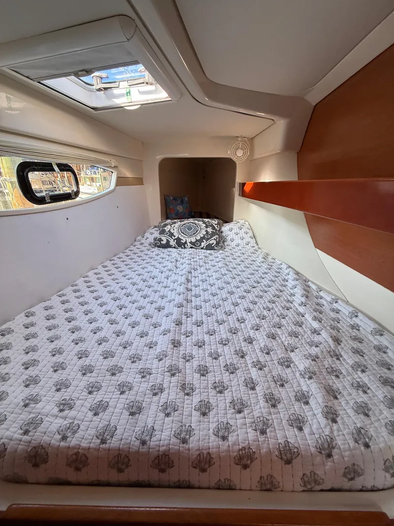 Slide: The Image of Cozy cabin interior of 2010 Leopard 38 yacht with patterned bedding and wooden accents. - 13