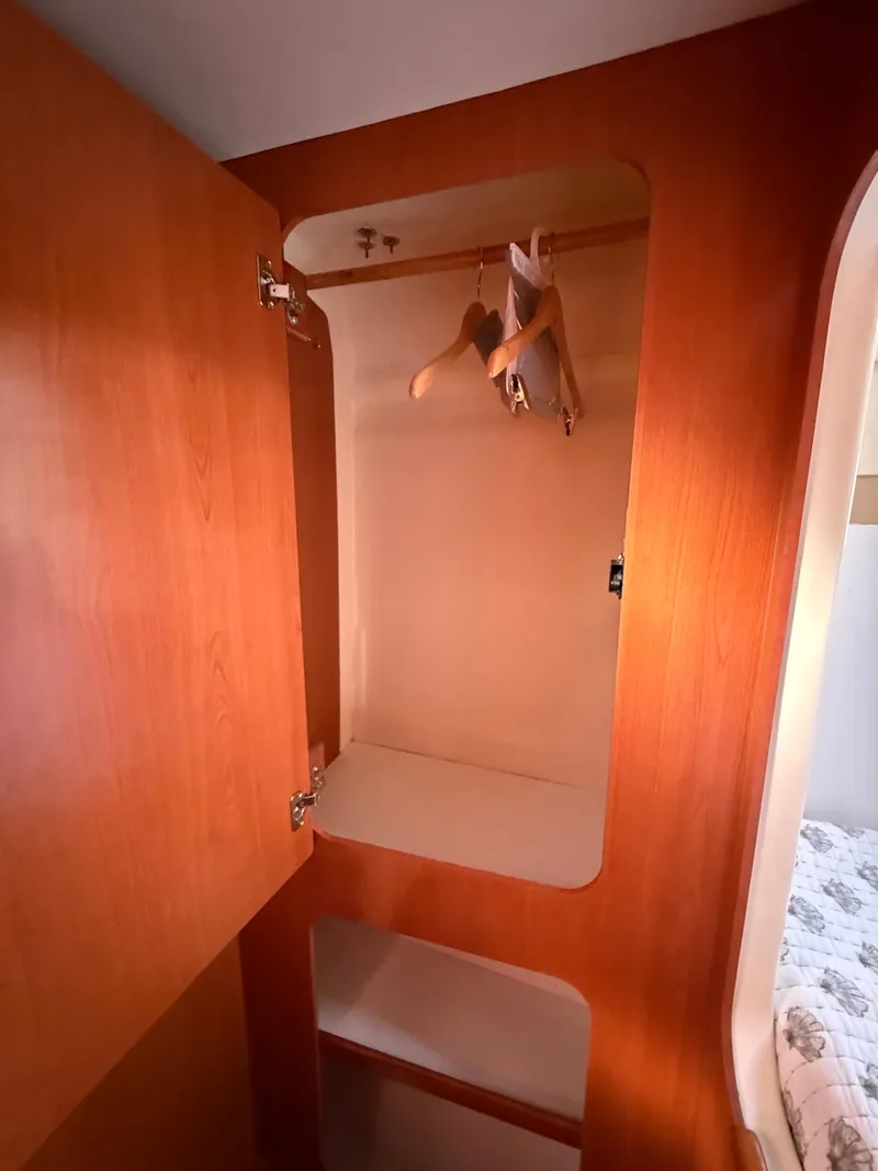 Slide: The Image of Wooden closet interior with hangers in a 2010 Leopard 38 model. - 14