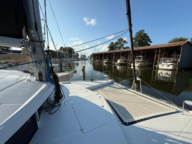 Slide: The Image of 2010 Leopard 38 catamaran docked in a serene marina with boats and trees. - 20