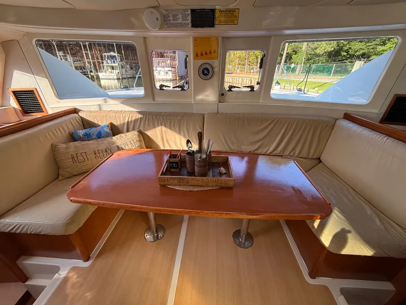 Slide: The Image of Cozy interior of 2010 Leopard 38 catamaran with wooden table and cushioned seating. - 3