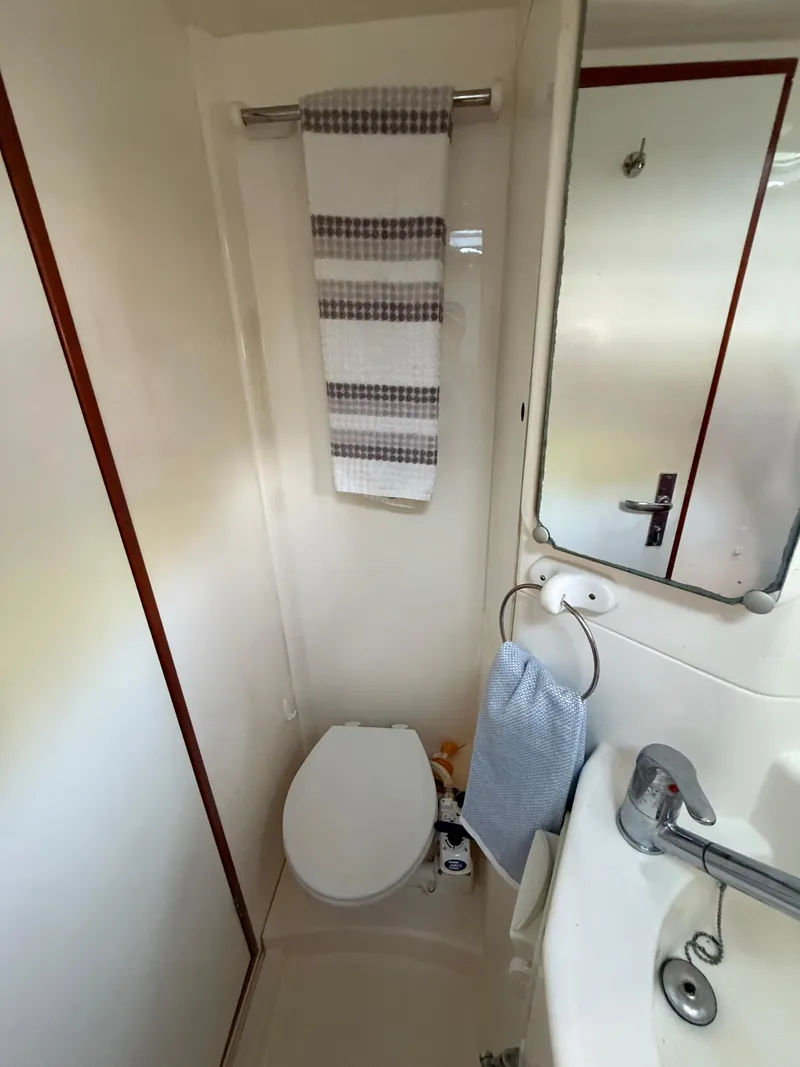 Slide: The Image of Compact bathroom in a 2010 Leopard 38 yacht with toilet, sink, and towel rack. - 5