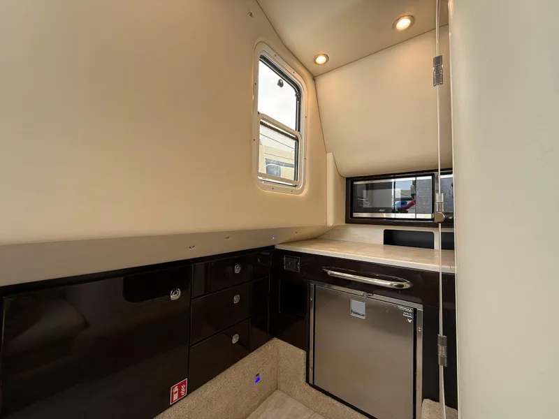 Slide: The Image of 2024 Formula 350 Crossover Bowrider interior with modern kitchenette and sleek cabinetry. - 32
