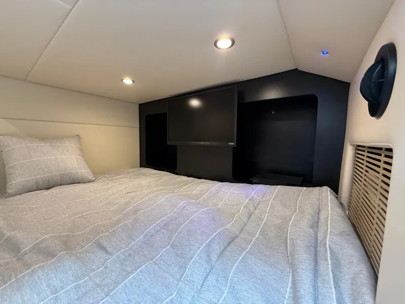 Slide: The Image of 2024 Formula 350 Crossover Bowrider cabin with bed and TV, modern interior design. - 37