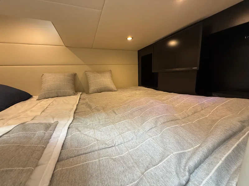 Slide: The Image of 2024 Formula 350 Crossover Bowrider cabin with cozy bed and TV. - 39