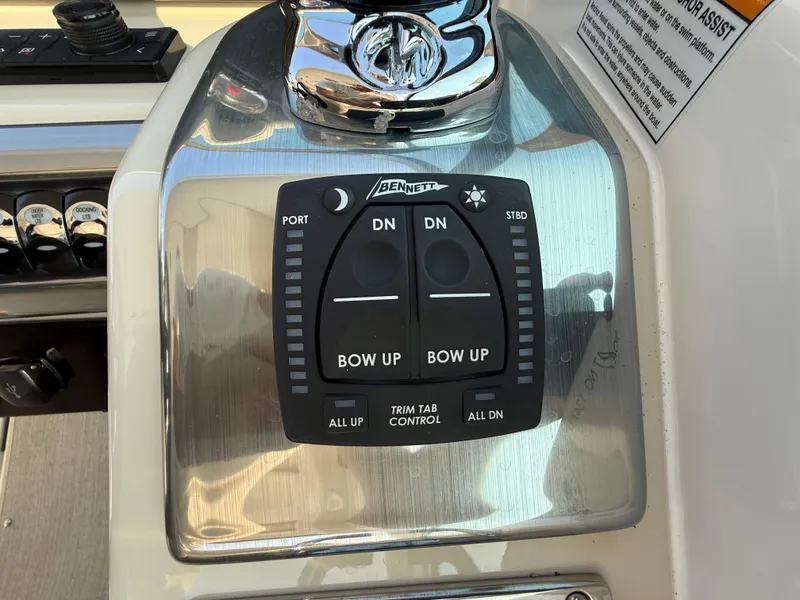 Slide: The Image of 2024 Formula 350 Crossover Bowrider trim tab control panel with buttons and indicators. - 52